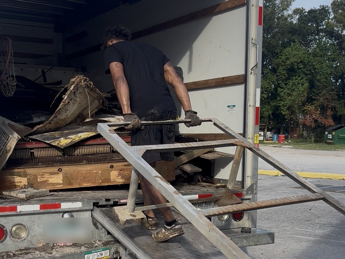 An Outlaw Junk & Yard crew member loading a box truck